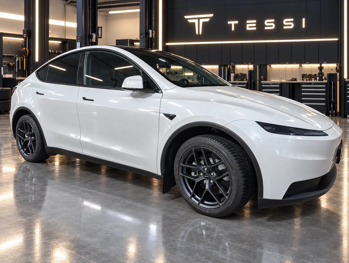 Weißer Tesla Model Y Juniper Standard mit Borbet Y E-Grey 19 Zoll Kompletträdern in der TESSI-Werkstatt, Seitenansicht