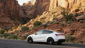 Tesla Model Y Juniper mit The New Aero Razor V2 Felgen 19 Zoll in Schwarz Matt, Seitenansicht auf Canyon-Straße
